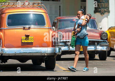 Havanna, Kuba - ca. Juni 2011: Fußgänger Spaziergänge zwischen den bunten amerikanischen Autos Taxifahrzeuge in Zentral-Havanna. Stockfoto