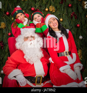 Santa Clause Frau lächelnd Elf Helfer sitzt auf Weihnachten Sessel Stockfoto