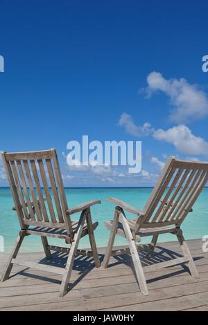 Zwei Stühle Betten im Wald am tropischen Strand mit blaue Meer im Hintergrund Stockfoto