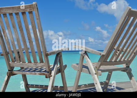 Zwei Stühle Betten im Wald am tropischen Strand mit blaue Meer im Hintergrund Stockfoto