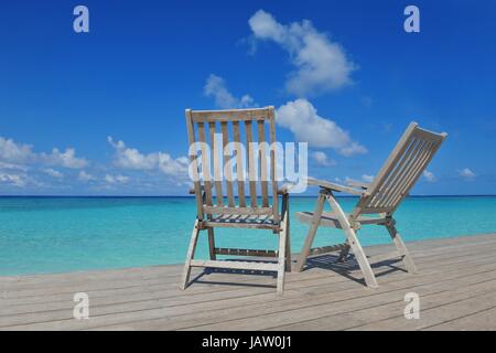 Zwei Stühle Betten im Wald am tropischen Strand mit blaue Meer im Hintergrund Stockfoto