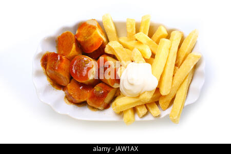 Scheiben vom geräucherten Bratwürste und knackig, die goldene Pommes Frites mit Mayonnaise in eine geriffelte weiße Schale, über den Kopf Blick auf weißem Hintergrund gekrönt Stockfoto