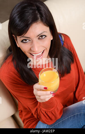 Kaukasische Mädchen trinken Saft von Orange mit einem Strohhalm Stockfoto