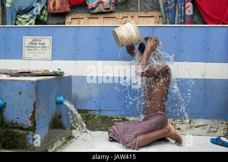 Ein Mann taucht selbst an einem Straßenrand Badeplatz in Kolkata (Kalkutta), Westbengalen, Indien Stockfoto