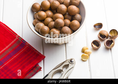 Macadamia-Nüssen in Schüssel auf weißer Holztisch Stockfoto