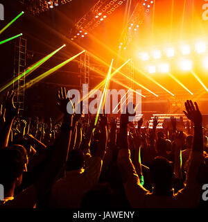 Foto von jungen Menschen, die Spaß am Rock-Konzert, aktiven Lebensstil, Fans applaudieren berühmte Musikgruppe, Nachtleben, dj auf der Bühne im Club, auf der Tanzfläche, Nacht Perfomance tanzende Menge Stockfoto