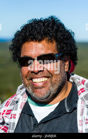 Ein lächelnder Aborigines Mann mit Sonnenbrille an einem sonnigen Tag. Stockfoto