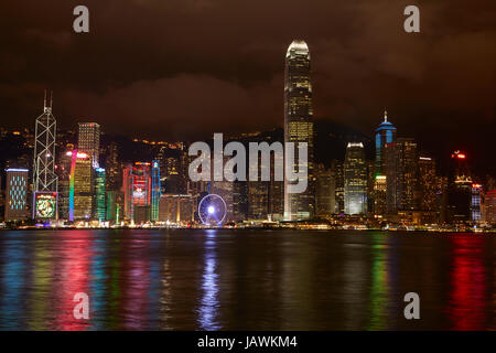 Lichtshow auf Wolkenkratzer und Hong Kong Riesenrad, spiegelt sich in Victoria Harbour, Central, Hong Kong Island, Hongkong, China Stockfoto