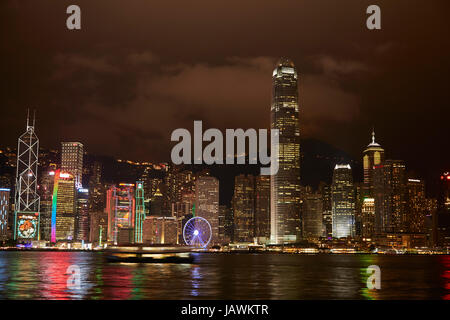 Lichtshow auf Wolkenkratzer und Hong Kong Riesenrad, spiegelt sich in Victoria Harbour, Central, Hong Kong Island, Hongkong, China Stockfoto