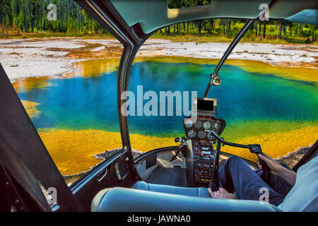 Helikopter-Cockpit mit pilot Arm und Kontrolle-Konsole in der Kabine Flug über bunte Abgrund Pool in West Thumb Geyser Basin von Yellowstone N Stockfoto