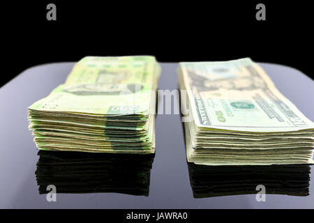 Eine Reihe von mexikanischen Pesos Rechnungen neben ein paar von uns Dollar Rechnungen Stockfoto