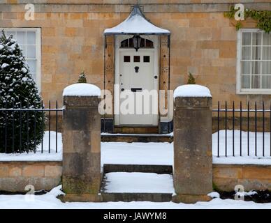 Cotswold Haus Eingang im Schnee, Broadway, Worcestershire, England. Stockfoto