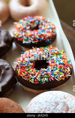 Bunte Streusel über Schokoladen Donuts aus Krispy Kreme Stockfoto