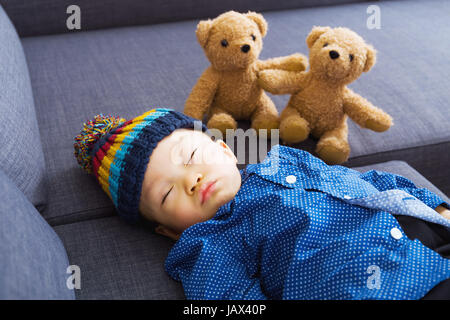 Asiatische Babyjungen schlafen mit Puppe Stockfoto