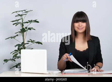 Junge Frau Sitzt bin Schreibtisch Und MotorrÃ Einen Aktenordner Stockfoto