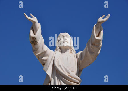 Jesus Christus mit Handzeichen in Segen unter blauem Himmel. Marmorstatue Grabbeigaben. Stockfoto