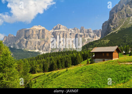 Sommerlandschaft in Fassa Tal mit einem kleinen Chalet unter Dolomiten, Trentino, Italien Stockfoto