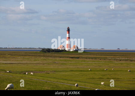 Westerhever Leuchtturm (Deutschland) aufgenommen bei Tageslicht mit einige Schafe auf dem Deich. Stockfoto