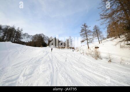 Off Piste Skipiste mit Loipen, einige Wanderer und malerischen Tal in den italienischen Alpen Stockfoto