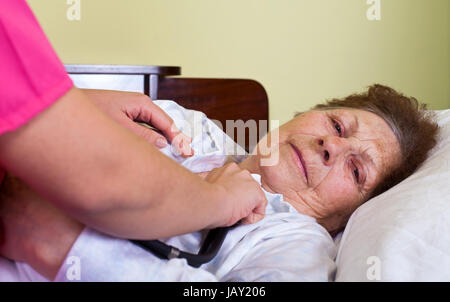 Bild einer kranken alten Frau zu Hause mit ihrer Pflegeperson Stockfoto