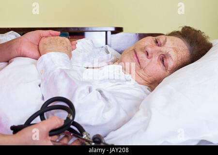 Bild von einer älteren Frau in Fieber, im Bett liegend Stockfoto