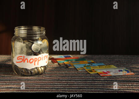 Münzen in Geld Glas mit Shopping label und Kreditkarten, Finanzen Konzept Stockfoto