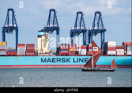 Thames Schiff Segeln vorbei an Maersk Line Containerschiff, Felixstowe Containerhafen, gesehen aus Harwich Essex England Stockfoto