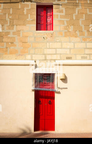 Drei blau hell farbige gelbe und rote Haustüren auf ein Apartment Gebäude in der Fischerei Hafen von Marsaxlokk Malta Stockfoto