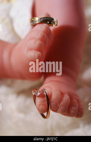 Reborn Puppe zeigt zwei goldene Ringe Stockfoto