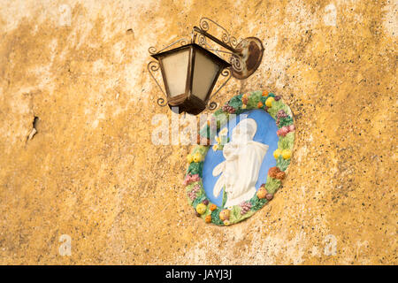Eine reich verzierte Metall Lampe und Gips Bild der Madonna mit Kind auf einer Hauswand in Malta Stockfoto
