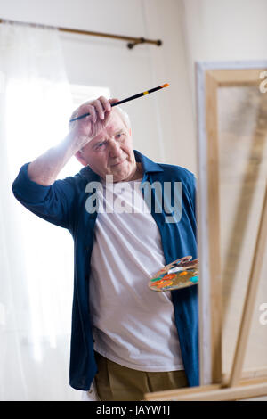 Porträt von müde senior woman Zeichnung Bild in der Kunstwerkstatt Stockfoto