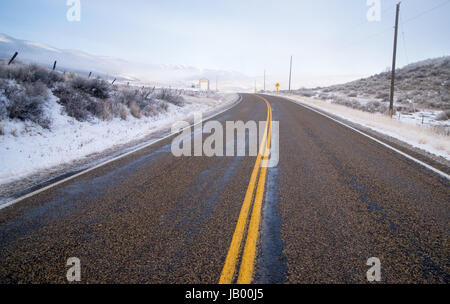 Eine vereiste Straße führt durch Szene Farm Ranch Hang Landstraße 71 Stockfoto