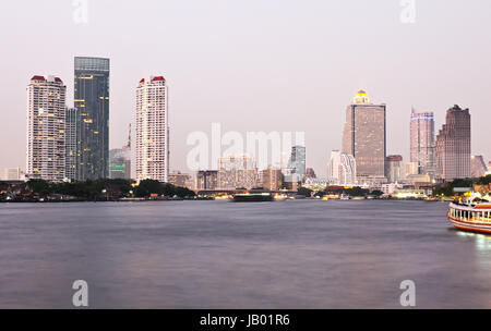 Gebäude entlang des Flusses bei Sonnenuntergang. Die Aussicht vom Asiatique. Sehenswürdigkeiten in Bangkok, Thailand. Stockfoto