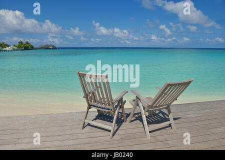 Zwei Stühle Betten im Wald am tropischen Strand mit blaue Meer im Hintergrund Stockfoto