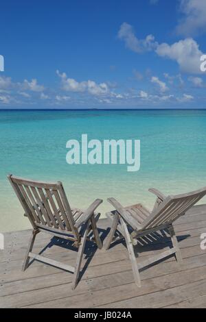 Zwei Stühle Betten im Wald am tropischen Strand mit blaue Meer im Hintergrund Stockfoto