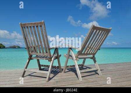 Zwei Stühle Betten im Wald am tropischen Strand mit blaue Meer im Hintergrund Stockfoto