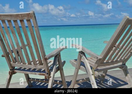 Zwei Stühle Betten im Wald am tropischen Strand mit blaue Meer im Hintergrund Stockfoto