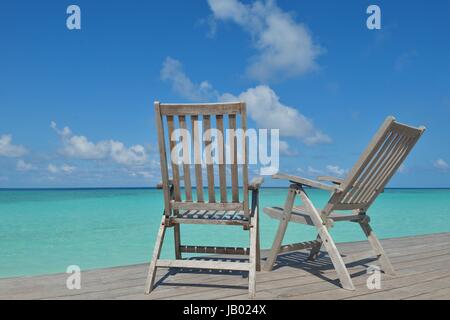 Zwei Stühle Betten im Wald am tropischen Strand mit blaue Meer im Hintergrund Stockfoto