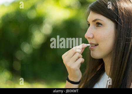 Frau nimmt eine Pille Stockfoto