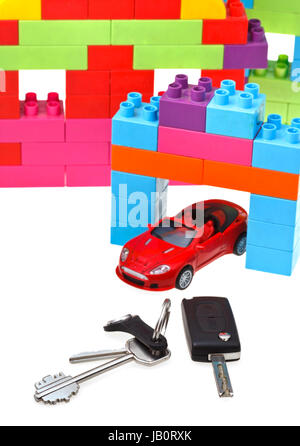 Tür, Fahrzeugschlüssel schließen sich rot Modellauto und Kunststoffblock Haus isoliert auf weißem Hintergrund Stockfoto