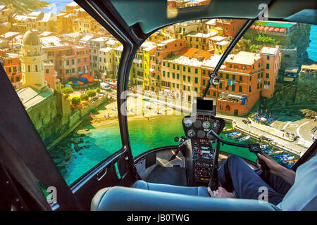 Helikopter-Cockpit mit pilot Arm und Kontrolle-Konsole in der Kabine im Luftbild von Vernazza bei Sonnenuntergang, ein Juwel der Cinque Terre Nationa Stockfoto