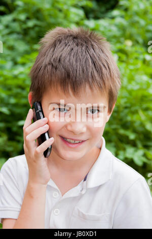 Junge reden über ein Handy im Sommergarten Stockfoto