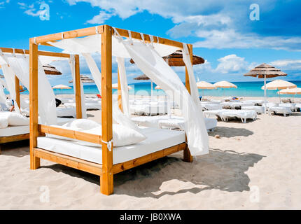 Blick auf einige Betten in einem Beach-Club in einem weißen Sandstrand in Ibiza, Spanien Stockfoto