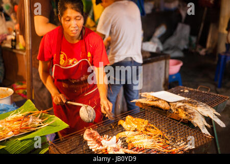 CHIANG MAI, THAILAND - 27 AUGUST: Frau kocht Garnelen und Tintenfische vom Grill am Sonntagsmarkt (Walking Street) am 27. August 2016 in Chiang Mai, T Stockfoto