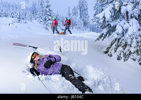 Skifahrer nach Unfall für Bergrettung im Schnee liegend Stockfoto