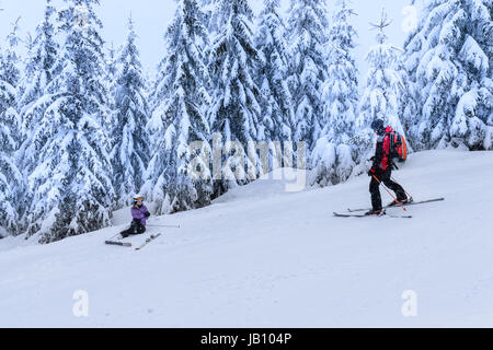 Ski Patrol Hilfe verletzte Frau Skifahrer im Schnee liegend zu retten Stockfoto