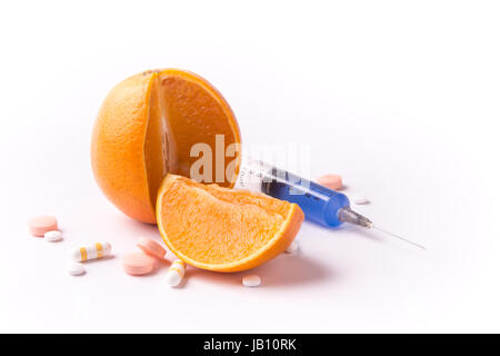 OGM orange Frucht mit Pillen und Spritze Stockfoto