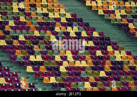 Leere Sitzreihen in verschiedenen Farben in einem Stadion Stockfoto