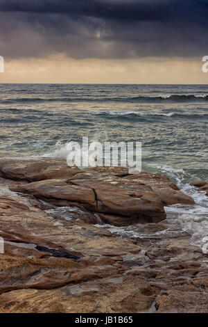 Schwere Wolken über die Wellen des Pazifischen Ozeans in Caloundra, Queensland, Australien. Sie prognostizieren einen Frühsommer-Sturm. Stockfoto