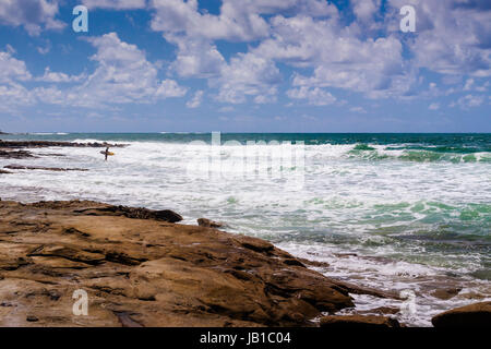 Ein Surfer, immer bereit für die Fahrt in Caloundra, Queensland, Australien. Es schien ein windiger Tag, muss seinen Mut bewundern. Stockfoto